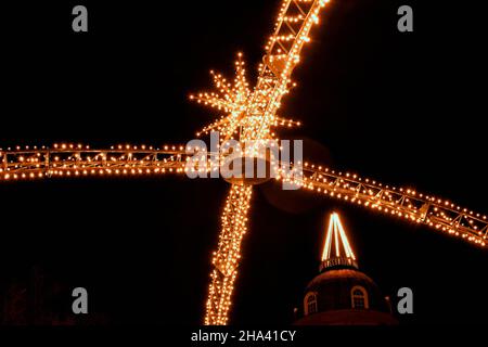 Il tradizionale arco natalizio di Königsallee a Düsseldorf/Germania con lo storico edificio illuminato Deutsche Bank sullo sfondo. Foto Stock