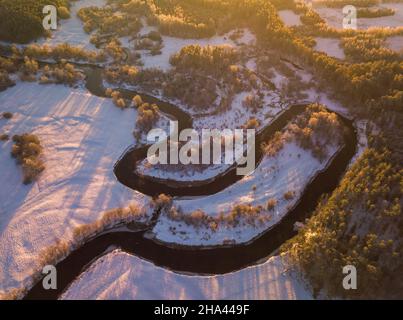 Vista aerea dall'alto verso il basso inverno curva del fiume con neve ghiacciata riva Foto Stock