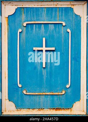 Vecchia croce di metallo sulla porta blu simbolo cristiano Foto Stock