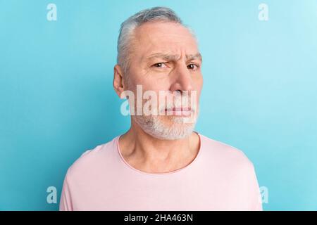 Ritratto di attraente sospetto stretto uomo grigio-capelli che guarda voi isolato su sfondo di colore blu brillante Foto Stock