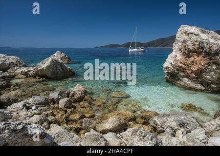 barca in agiofili spiaggia vicino al porto di vasiliki con mare cristallino smeraldo, lefkada isola, ionio, grecia. Foto Stock