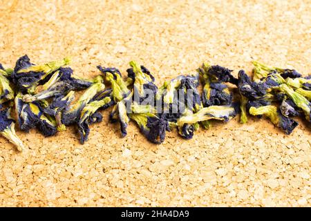 Lotto di clitoria ternatea secca intera sulla superficie di sughero Foto Stock