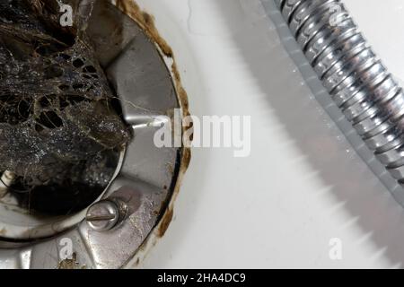 Sifone di scarico dei capelli nella doccia. Molti peli hanno causato un'ostruzione del tubo e danni all'acqua. Primo piano Foto Stock