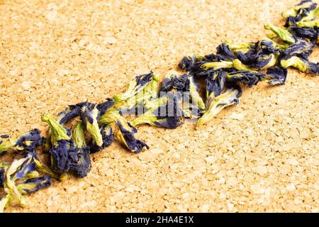 Lotto di clitoria ternatea secca intera sulla superficie di sughero posizionata diagonalmente Foto Stock