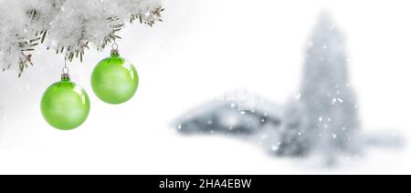 due palle verdi di natale su un ramo di pino innevato Foto Stock