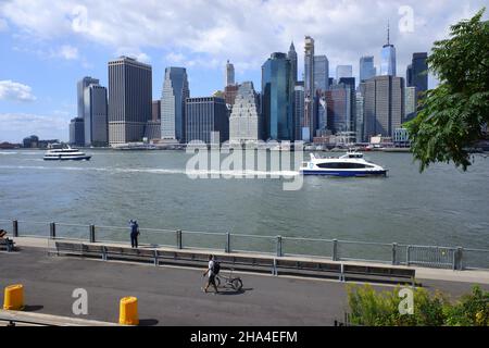 La vista del quartiere finanziario di Lower Manhattan e un traghetto a East River dal Granite Prospect a Brooklyn Bridge Park.Brooklyn.New York City.USA Foto Stock