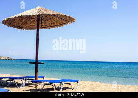 Due lettini sotto l'ombrellone in spiaggia. Spiaggia di Zephyros. Grecia Foto Stock