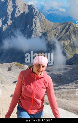 giovani donne che camminano verso zugspitze, wetterstein montagne cielo blu, nuvole, umore nuvoloso, garmisch-partenkirchen, loisachtal, alta baviera, baviera, germania meridionale, germania, europa, Foto Stock