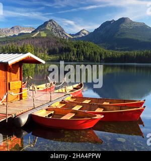 Paesaggio di montagna con belle barche rosse sul lago. Slovacchia, lago Strbske Pleso Foto Stock