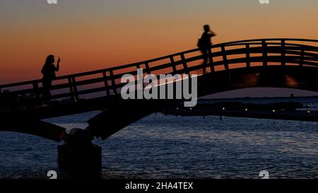 grecia,isole greche,isole ionie,lefkada o lefkas,lefkada città,capitale,crepuscolo,atmosfera serale,tramonto,ponte di legno,ponte,su di esso due persone come una silhouette,una fotografando l'altra,arancio cielo Foto Stock