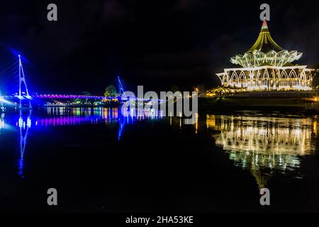 Vista notturna del Ponte Darul Hana e del Palazzo dell'Assemblea legislativa dello Stato di Sarawak a Kuching, Malesia Foto Stock