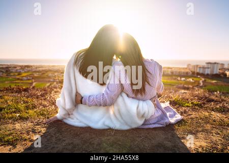 Due migliori girlfriends o sorelle che si abbraccia e si godono la vita al tramonto. Amici che trascorrono del tempo insieme. Amici per sempre Foto Stock