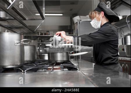 Ritratto di fiducioso chef femminile che lavora in cucina commerciale. Foto di alta qualità Foto Stock