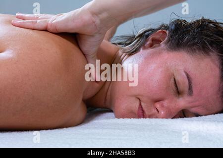 Massaggiatore femminile che fa un massaggio alle spalle di un'altra donna. Massaggio energetico o reiki Foto Stock