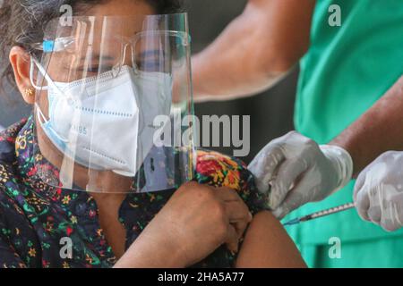 Colombo, Sri Lanka. 10th Dic 2021. Una medaglia dell'esercito dello Sri Lanka inocula una donna con un richiamo del vaccino del coronavirus Covid-19 in un centro di vaccinazione a Colombo il 10 dicembre 2021. (Foto di Saman Abesiriwardana/Pacifi Press) Credit: Sipa USA/Alamy Live News Foto Stock