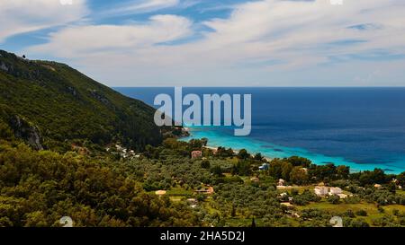 grecia,isole greche,isole ionie,lefakada o lefkas,monastero di faneromeni,vista verso il basso sulla costa,colline verdi,mare turchese-blu,cielo blu con nuvole bianche Foto Stock