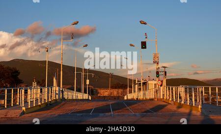 grecia,isole greche,isole ionie,lefakada o lefkas,lefkada city,capitale,crepuscolo,swing bridge,faro,swing bridge testa-su verso la strada,lanterne sinistra e destra,cielo blu,nuvole grigie e bianche Foto Stock