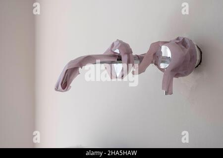 cantiere, ristrutturazione e ristrutturazione di un appartamento, dettaglio del rubinetto d'acqua con nastro Foto Stock