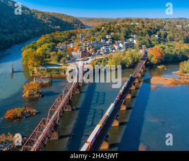Splendida vista aerea di ponti sull'acqua, alberi, case e un cielo blu nella città di Harpers Ferry, Stati Uniti Foto Stock