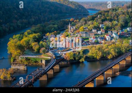 Splendida vista aerea di ponti sull'acqua, alberi, case e un cielo blu nella città di Harpers Ferry, Stati Uniti Foto Stock