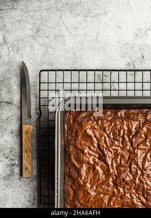 Vista dall'alto dei brownie di cioccolato in padella di raffreddamento su una rastrelliera metallica. Foto Stock