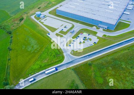 Vista aerea di merci di magazzino. Centro di logistica industriale in zona della città dall'alto. Vista aerea di camion caricamento al centro logistico Foto Stock