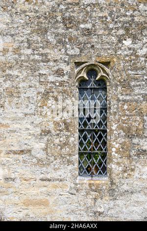 Particolare della parte superiore in acciaio, la finestra a lancetta nella parete esterna della Chiesa di St Oswald, Swinbrook e Widford, Oxfordshire, Inghilterra Foto Stock