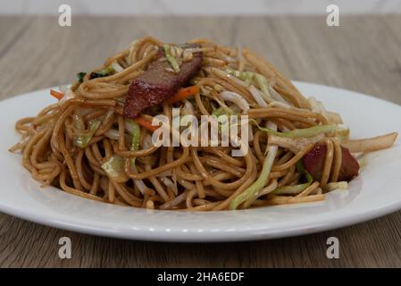 Il barbeque chow mein di maiale e le spaghetti abbondanti riempiono questo piatto con un delizioso pasto cinese. Foto Stock