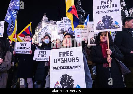 Londra, Regno Unito. 10th Dic 2021. Un protestore in prima linea canta mentre tiene un cartello che dice 'Free Uyghurs. Giochi di genocidio 'durante la protesta. In occasione della Giornata dei diritti umani (10th Dic), vari gruppi del Partito Comunista anti-Cinese (anti-CCP) a Londra si sono radunati a Piccadilly Circus, in seguito marciando verso il 10 Downing Street. Foto Stock