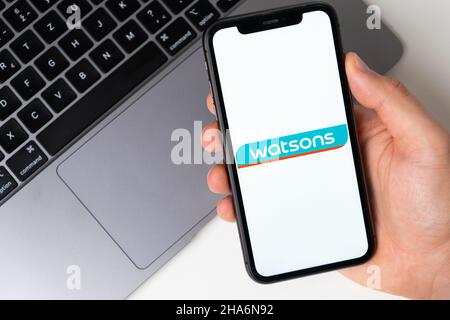 Watsons l'applicazione è aperta nello smartphone. L'uomo sta tenendo un telefono cellulare in mano, l'applicazione aziendale è aperta sullo schermo. Acquisti online sicuri. Novembre 2021, San Francisco, USA Foto Stock