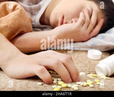 L'adolescente dorme vicino alle pillole sul letto Foto Stock