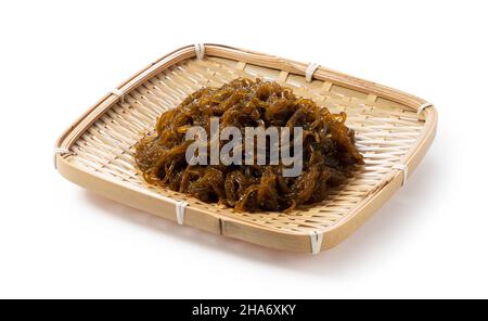 Mozuku in un colander su sfondo bianco.Mozuku è una prelibatezza Okinawan. Si tratta di un tipo di alga scura, filata condita con aceto Foto Stock