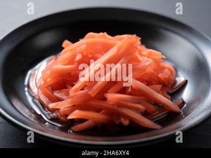 Zenzero sott'aceto rosso posto su sfondo nero. Immagine dello zenzero sott'aceto rosso in Giappone. Foto Stock