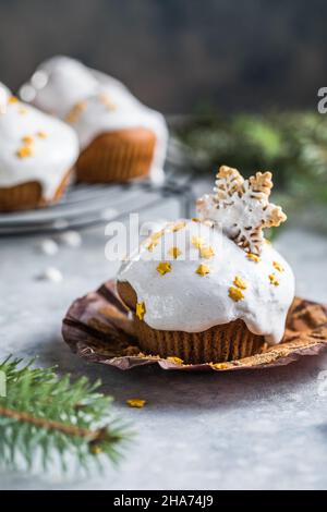 Cupcake di Natale. Dessert di Natale con gocce di cioccolato e marshmallow. Sfondo in legno con decorazioni natalizie e rami di abete. Foto Stock