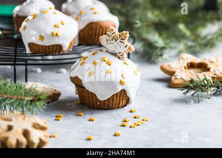 Cupcake di Natale. Dessert di Natale con gocce di cioccolato e marshmallow. Sfondo in legno con decorazioni natalizie e rami di abete. Foto Stock