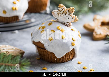 Cupcake di Natale. Dessert di Natale con gocce di cioccolato e marshmallow. Sfondo in legno con decorazioni natalizie e rami di abete. Foto Stock