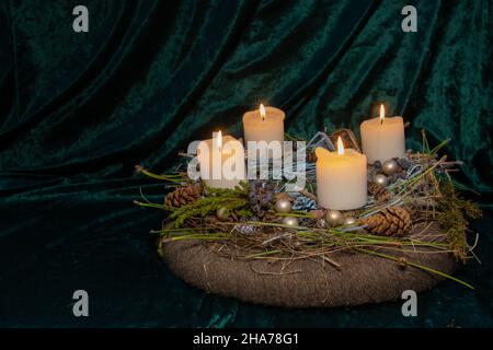 Quarto Avvento - la corona di Avvento self made con fuoco selettivo sul primo piano con quattro candele bianche che bruciano, una tradizione nelle quattro settimane prima di Chris Foto Stock