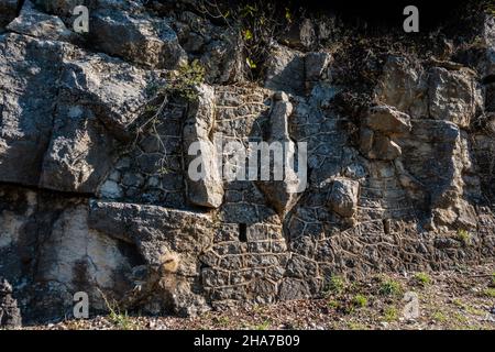 muro di pietra artificiale costruito nella roccia scogliera faccia Foto Stock