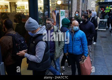 Le persone si accaparrano al di fuori del Rough Trade a Bristol, dove viene venduta una T-shirt disegnata dall'artista di strada Banksy per sostenere quattro persone accusate di danni criminali in relazione alla rovesciamento di una statua del commerciante di schiavi Edward Colston. Data foto: Sabato 11 dicembre 2021. Foto Stock