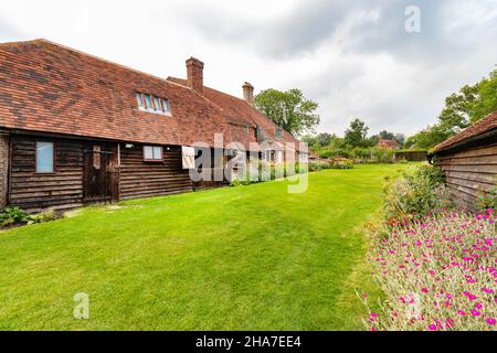 Affascinante rustica casa di campagna Smallhythe Place con esterno in legno, circondata da prato verde e fiori in fiore in una giornata nuvolosa. kent Foto Stock