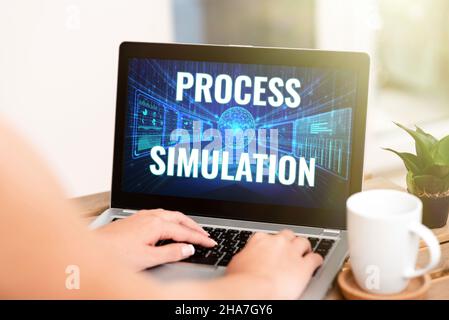 Segno di testo che mostra la simulazione del processo. Concetto significato rappresentazione tecnica Prollato Studio di un sistema di digitazione a mano sul laptop accanto al Coffee Mug Foto Stock