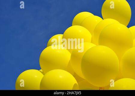 palloncini gialli nel festival della città contro il cielo blu Foto Stock