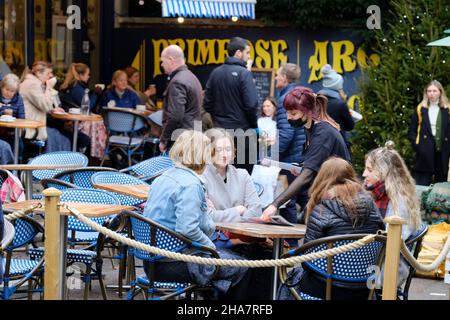 Clifton, Bristol, Regno Unito. 11th Dic 2021. Le persone fanno i loro acquisti pre-Natale in up-market Clifton per le preoccupazioni sulla variante Omicron Covid-19 aumento. Alcune persone indossano maschere all'esterno e altre no. È sempre il momento di fermarsi al Primrose Cafe. Credit: JMF News/Alamy Live News Foto Stock