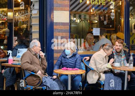 Clifton, Bristol, Regno Unito. 11th Dic 2021. Le persone fanno i loro acquisti pre-Natale in up-market Clifton per le preoccupazioni sulla variante Omicron Covid-19 aumento. Alcune persone indossano maschere all'esterno e altre no. È sempre il momento di fermarsi al Primrose Cafe. Credit: JMF News/Alamy Live News Foto Stock