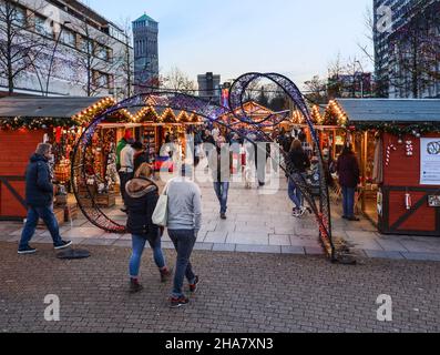 Le luci di Natale donano un tocco di calore alle piccole bancarelle di legno del mercatino di Natale di Plymouth, sulla Piazza del Centro Città Foto Stock