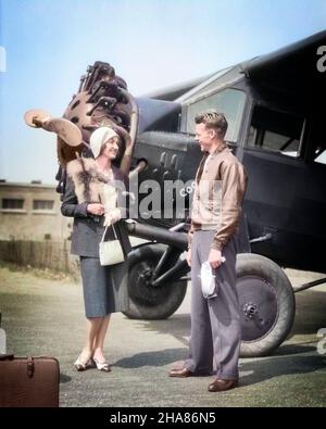 1920S DONNA VESTITA ALLA MODA PARLANDO CON PILOTA DI AEROPLANO INDOSSANDO GIACCA IN PELLE IN PIEDI DA AEREO MOTORE ELICA RADIALE - A9228C HAR001 HARS 1 VELIVOLO STILE COMUNICAZIONE CARRIERA GIOVANE ADULTO FELICE GIOIA LIFESTYLE AEREI STORIA FEMMINE LUSSO PASSEGGERO COPIA SPAZIO AMICIZIA FULL-LENGTH DONNE PERSONE MASCHI FOX PROFESSIONE FIDUCIA TRASPORTO OCCUPAZIONE DEL CLIENTE FELICITÀ ELICA ALLEGRO AVVENTURA AEROPLANI STILI DI CARRIERA CLOCHE BY AVIATION OCCUPATIONS SORRIDE ALLA MODA ACCANTO A GIOIOSA MODA COOPERATRICE ELEGANTE UOMO MEDIO-ADULTO UOMO MEDIO-ADULTO DONNA MOTORE RADIALE GIOVANE UOMO ADULTO Foto Stock