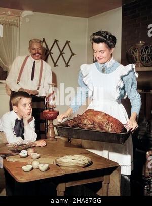 1950S MOCK GIRO DEL 20TH SECOLO CENA DI RINGRAZIAMENTO MAMMA SORRIDENTE MOSTRANDO TACCHINO ARROSTO PER COMPIACERE MARITO E FIGLIO SORPRESO - F1757C DEB001 HARS INTERNO TRE CASALINGA DA SOLA MOGLIE TURCHIA INSIEME GREMBIULE COPPIE MARITO COSTUME 3 LAMPADA DAD INDOOR APPLE AUTUNNO PASTO ARROSTO MOM ABBIGLIAMENTO TORTA AL COPERTO THANKSGIVING COTTURA STUFA NOSTALGICO CUOCO COPPIA SUBURBAN COLORE RELAZIONE MADRI SORPRESI CASA VECCHIO TEMPO OCCUPATO SORPRESA NOSTALGIA VECCHIA MODA 1 GIOVANE STILE PAN FIGLI FELICE GIOIA PARENTING CELEBRAZIONE SPOSATO RELAZIONE RITRATTI CONIUGE RURALE MARITI GROWNUP HOME VITA PREPARARE SPAZIO COPIA Foto Stock