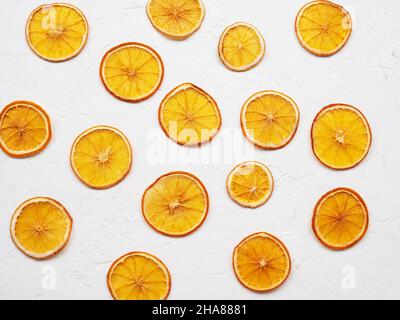 Frutta croccante disidratata per la decorazione di piatti per bevande e dessert. Fette di arancia secca o patatine su sfondo bianco. Mucchio, mucchio di sole asciugato Foto Stock