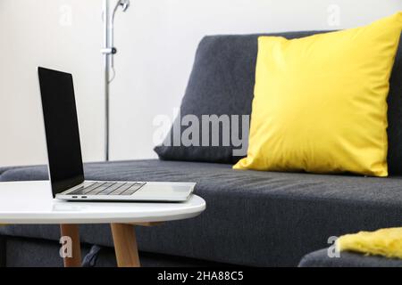 Lavorare da casa pic, aprire laptop su tavolo da divano, ufficio a casa Foto Stock