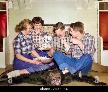 1950S GRUPPO ADOLESCENTI POP CORN SORRIDENDO RIDENDO SCHERZANDO INTORNO A ORSO PELLE TAPPETO CAMINO INDOSSANDO MAGLIETTE A PLAID JEANS - J3343C LAN001 HARS RELAZIONE VECCHIO TEMPO NOSTALGIA VECCHIA MODA STILE GIOVANILE RIDERE TEAMWORK TAPPETO FELICE GIOIA LIFESTYLE CELEBRAZIONE FEMMINE RURALE SALUTE HOME VITA COPIA SPAZIO AMICIZIA FULL-LENGTH PERSONE MEZZA LUNGHEZZA STOFFA MASCHI ADOLESCENTE RAGAZZA ADOLESCENTE RAGAZZO PLAID DENIM PELLE POPCORN DATAZIONE FELICITÀ ALLEGRO DIVERTIMENTO PER IL TEMPO LIBERO CAMICIE ATTRAZIONE SORRIDE CORTEGGIAMENTO CONCETTUALE LOAFERS FLANEL GIOIOSO POP ELEGANTE ADOLESCENTE BOBBY SOX POSSIBILITÀ BLU JEANS CRESCITA SCHERZANDO GIOVANI Foto Stock